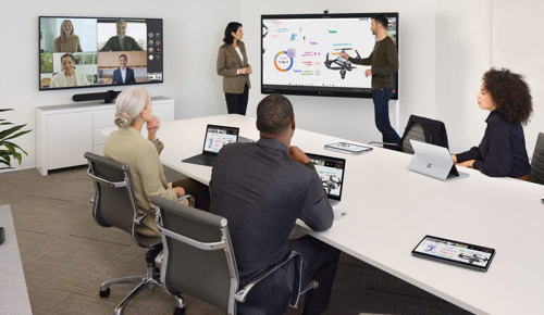 office meeting around a tv with date being shown